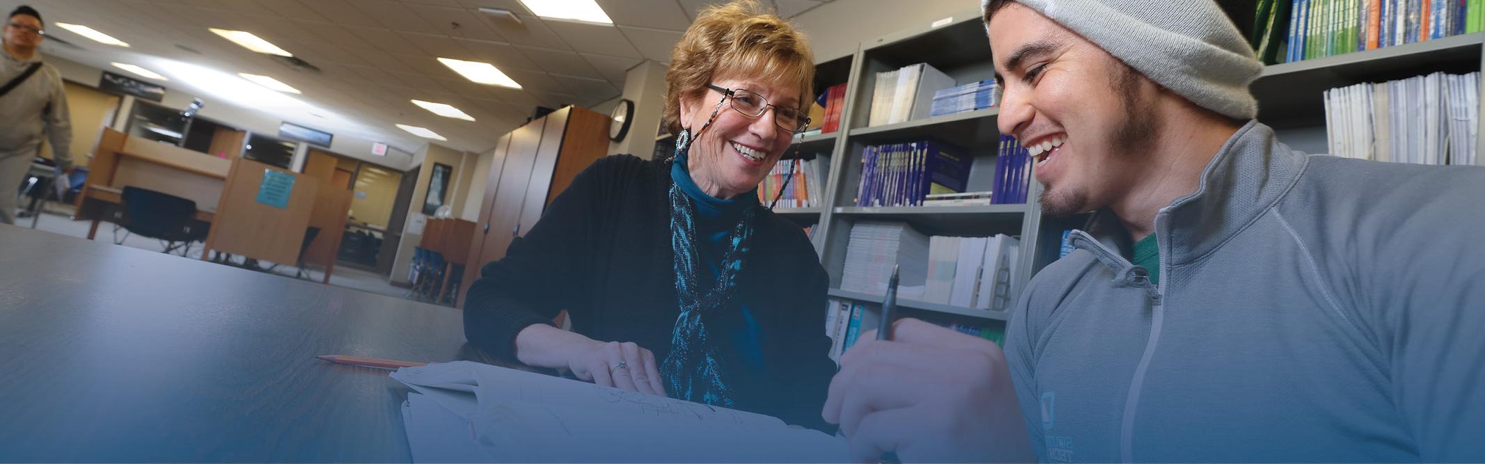 Student and tutor in library setting