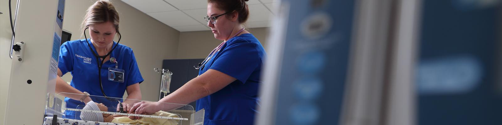 Southeast Tech taking blood pressure of a patient in a hospital bed